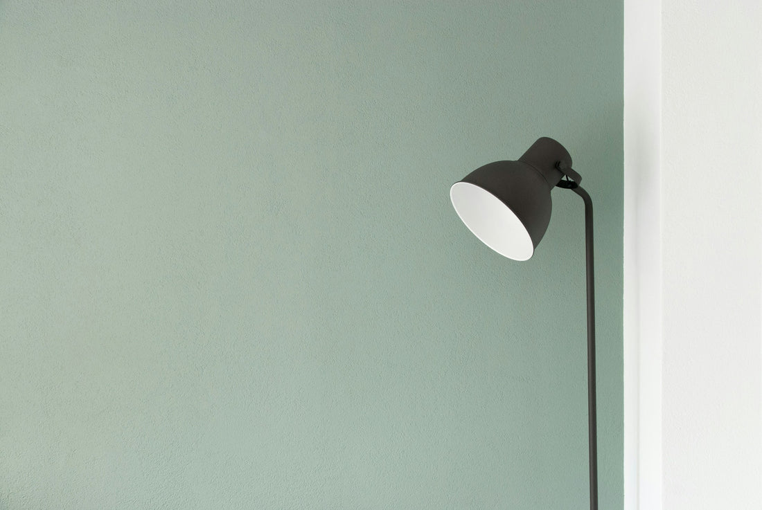 Black floor lamp standing in the corner of a minimal, calm room