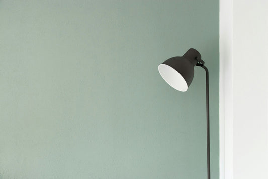 Black floor lamp standing in the corner of a minimal, calm room