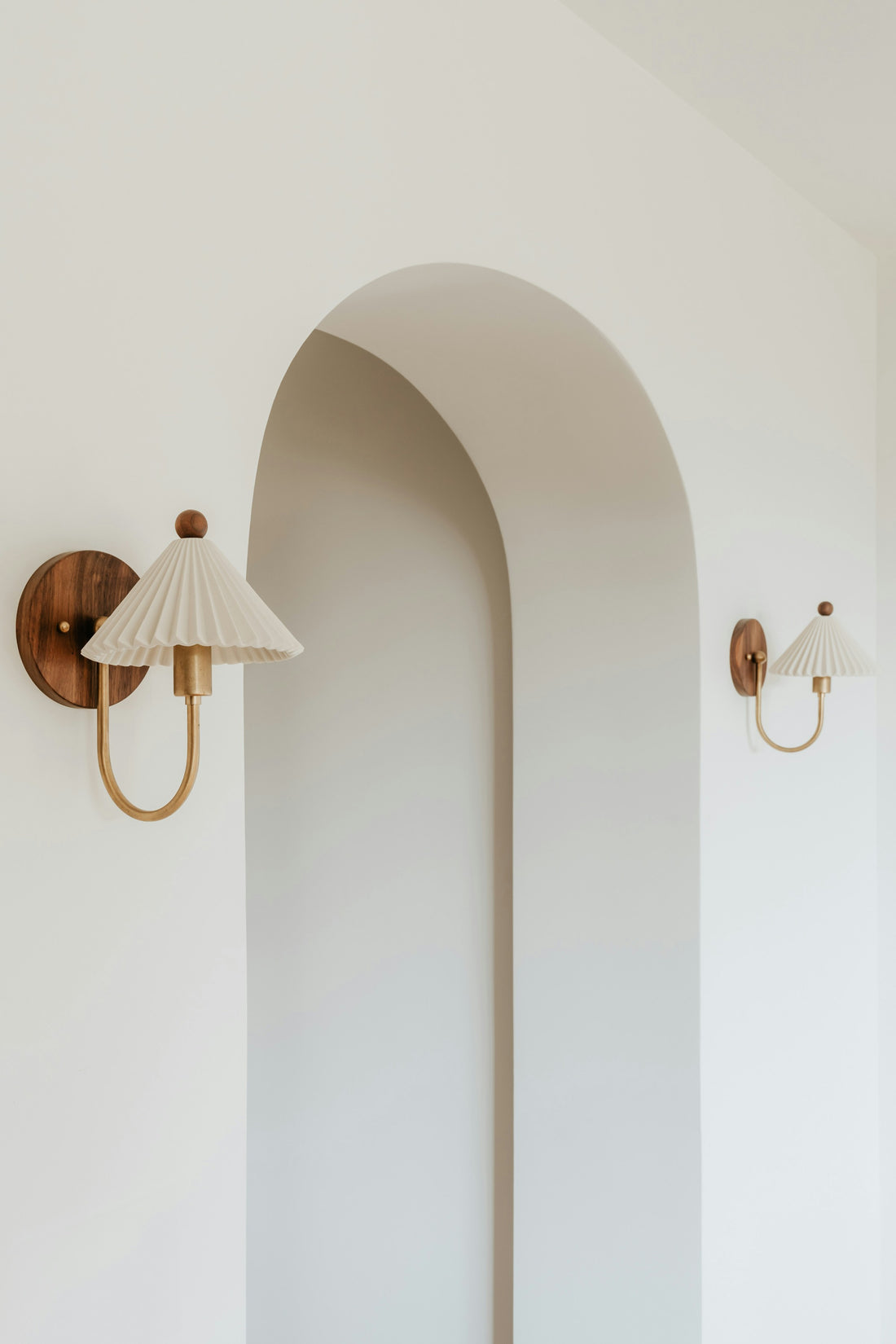 Bright minimal room with two wall sconces mounted symmetrically on a white wall