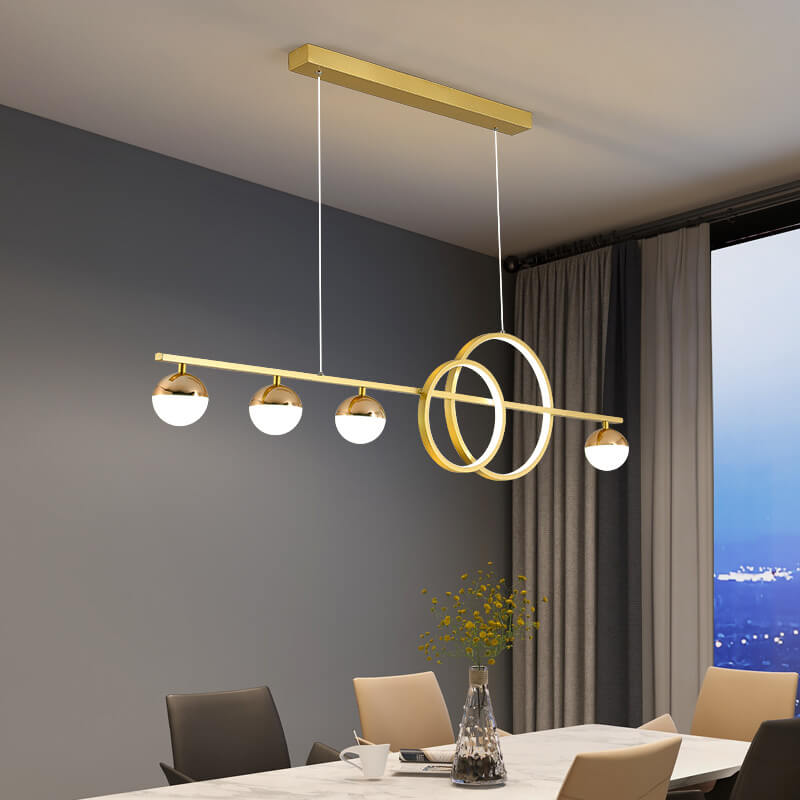Gold ring and globe linear LED chandelier over a dining table