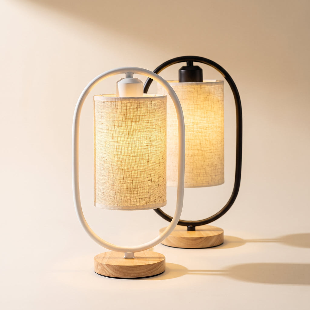 Oval frame table lamps in White and Black with linen shades, glowing on a cream background