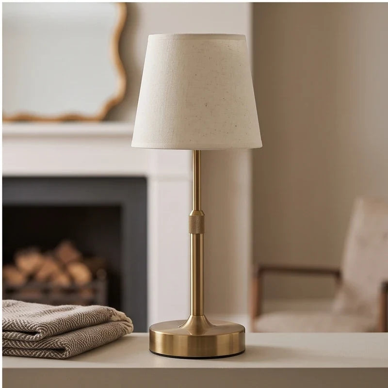 Gold cordless table lamp with slender adjustable stem and conical fabric shade